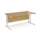 An oak desk with a white cantilever frame.