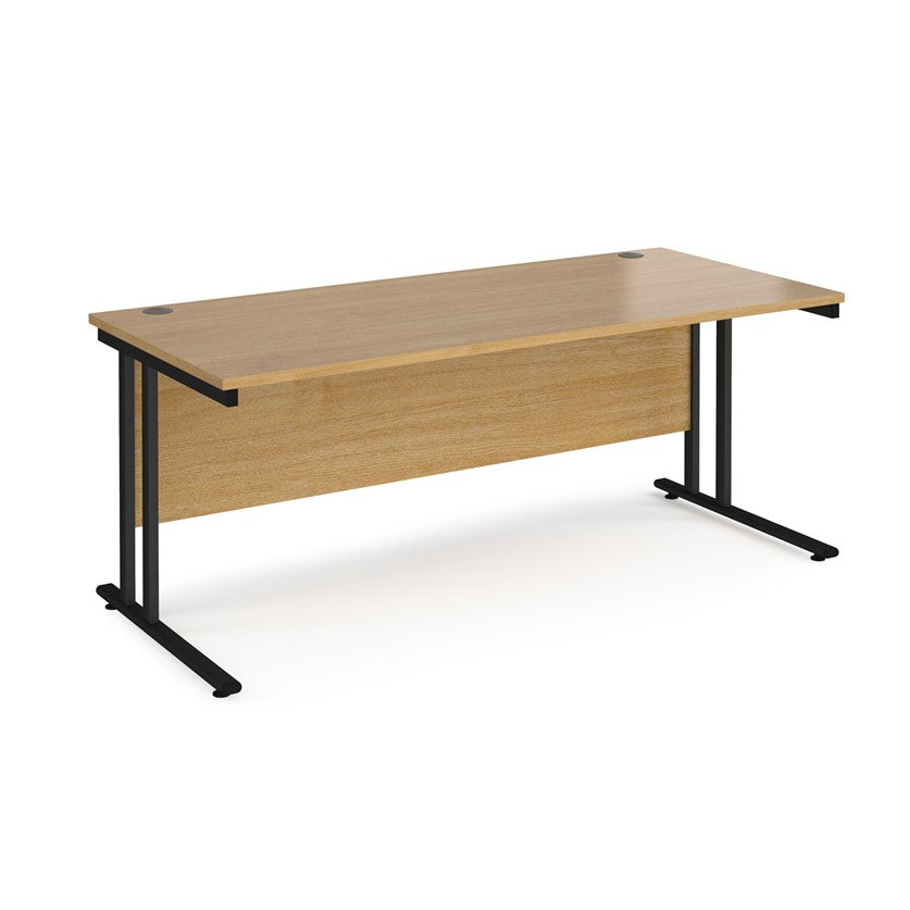 An oak desk with a black cantilever frame. 