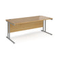 An oak desk with a grey cantilever frame.