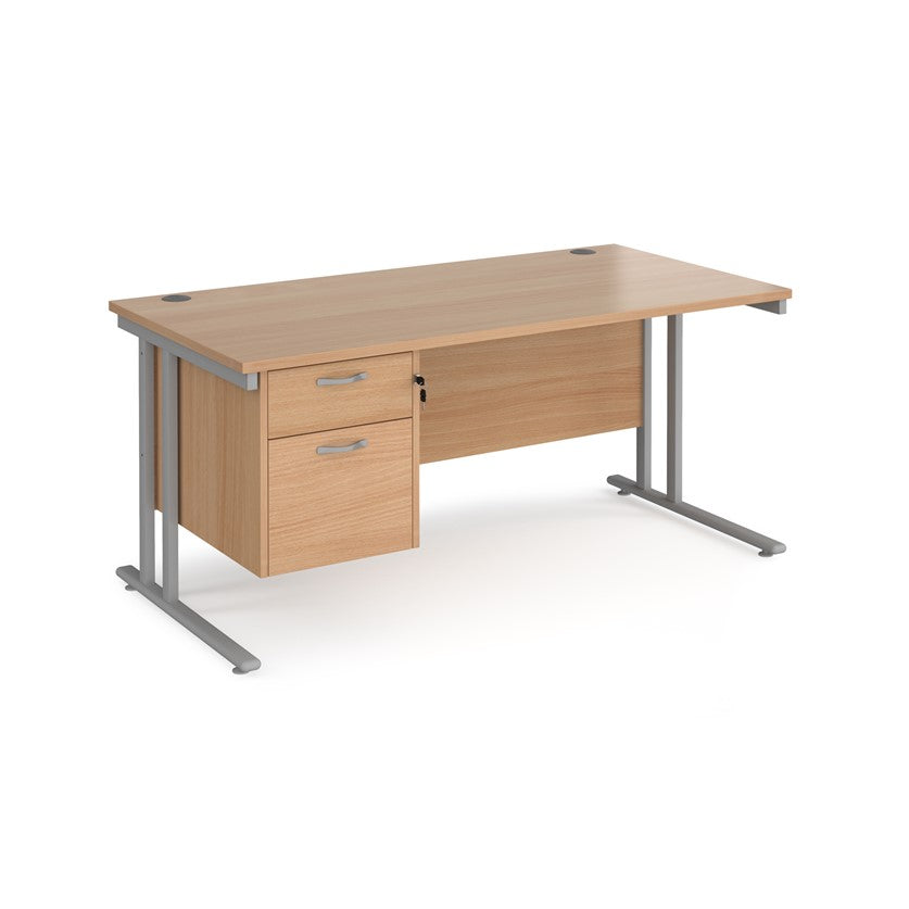 Rectangular office desk with a cantilever frame and a beige two-drawer fixed pedestal. The desk has a melamine finish and is pictured against a white background.

