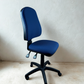 Blue office chair on a beige carpet with a white wall background