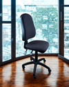 Almost office chair in front of large windows with a cityscape view
