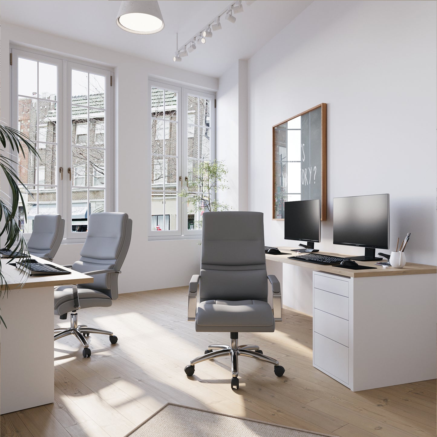 Modern office space with desks, chairs, and computer monitors.