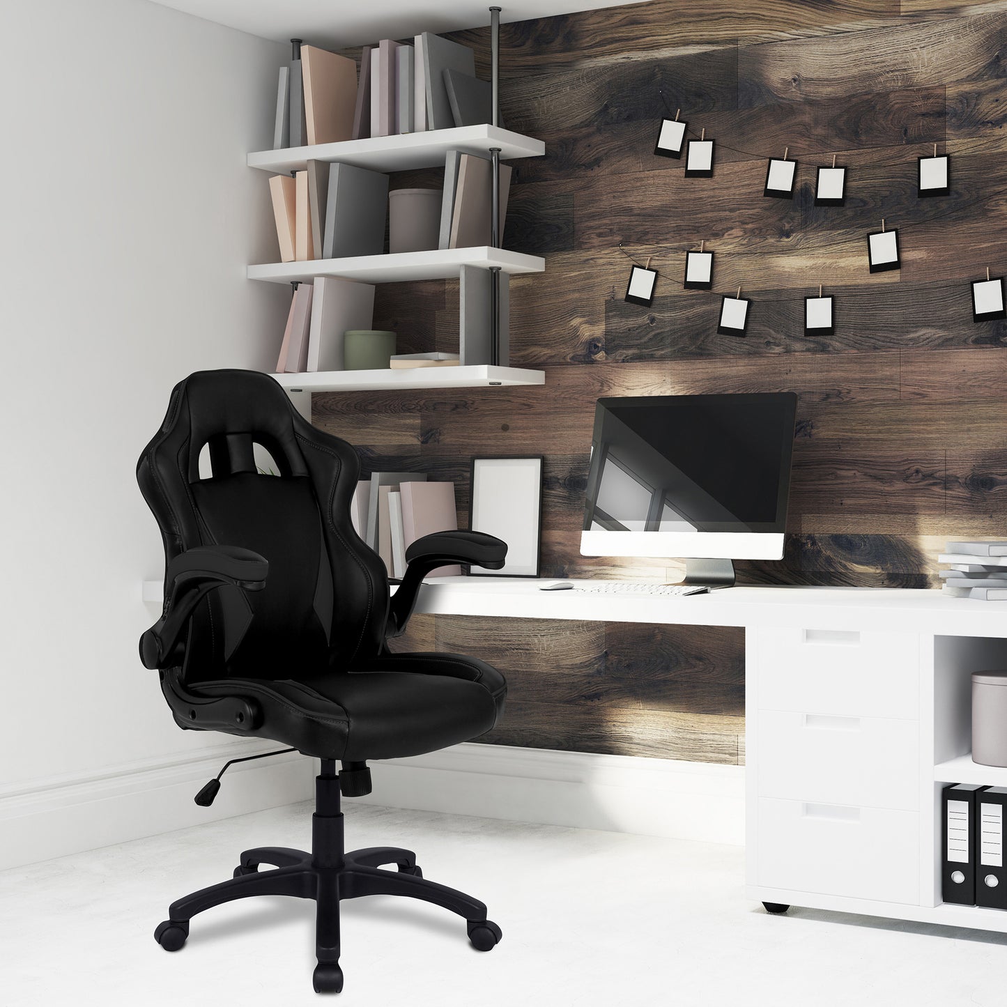 Modern office setup with black chair, desk, and wall decorations.