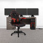 Black and red gaming chair in front of a desk with multiple monitors on a white brick wall background.