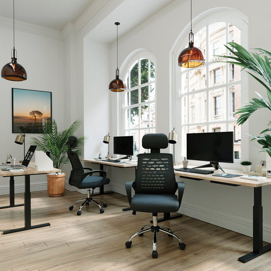 Modern office setup with ergonomic chairs, desks, and large windows.