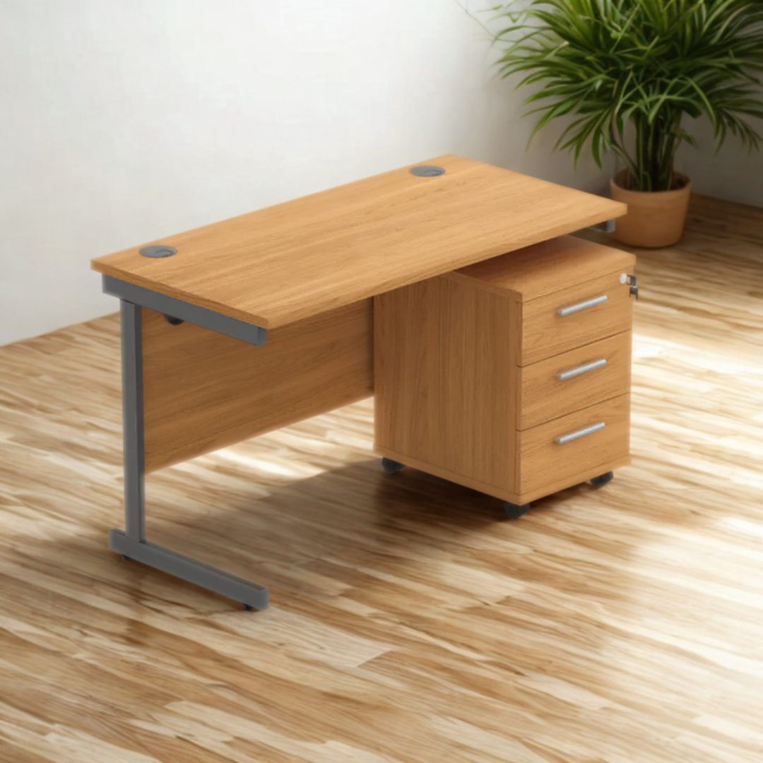 Wooden office desk with drawers on a wooden floor, plant in the background