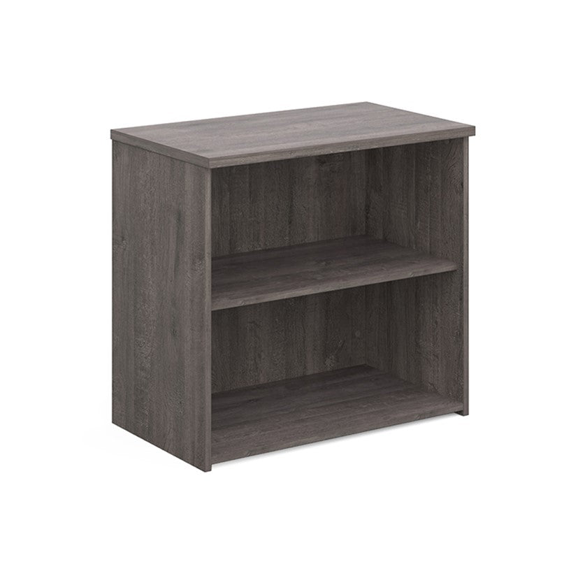 A wooden bookcase with a single opening tambour door and two shelves with a grey finish. 