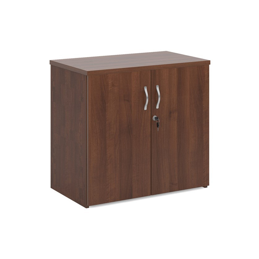 A wooden cupboard with walnut finish, featuring a pair of lockable doors with silver handles and a solid back panel.