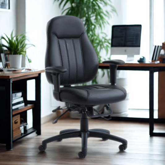 Black office chair in an office setting with a desk and computer in the background.