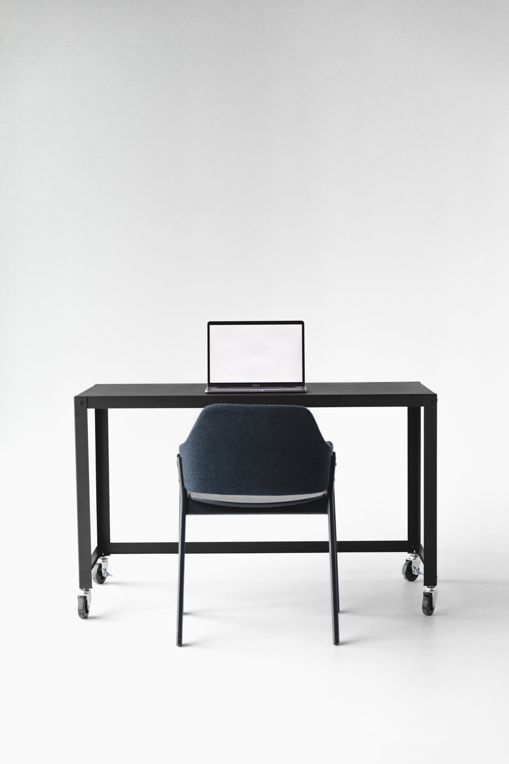Office chair and desk setup viewed from the front, showing back height and armrest position